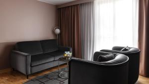 a living room with a couch and a chair at Hotel Hasselbacken in Stockholm