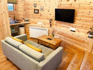 a living room with a couch and a wooden wall at High Parks in Bedale