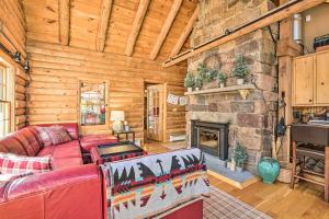 a living room with a red couch and a stone fireplace at Accord Vacation Rental with Pool and Hot Tub! in Accord