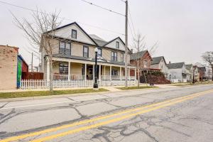 an empty street with a house with a white fence at Roomy Vacation Rental in Downtown Fort Wayne! in Fort Wayne