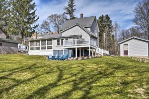 une grande maison blanche avec deux chaises bleues dans une cour dans l'établissement Gambier Vacation Rental about 5 Mi to Mt Vernon!, à Gambier