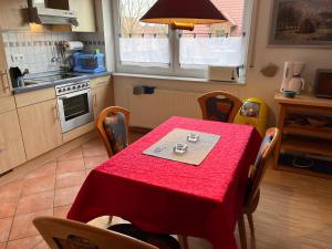 a kitchen with a table with a red table cloth at Fewo Kurth - Haus Dulshorn in Wildeshausen +10 photos
