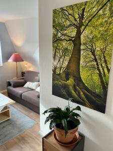 a living room with a large tree painting on the wall at Fewo Kurth - Haus Dulshorn in Wildeshausen