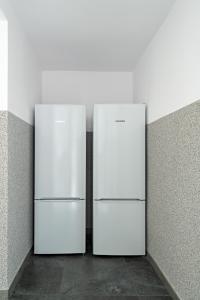 two white refrigerators are standing in a room at Noclegi Krańcowa in Zgorzelec