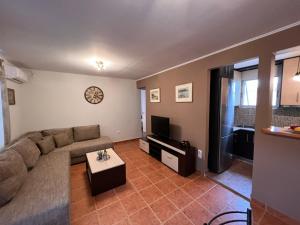 a living room with a couch and a tv at Avli Cottage in Sami