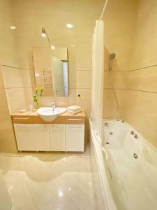 a white bathroom with a tub and a sink and a bath tub at Modern apartment,24/7 security,free parking in Belgrade