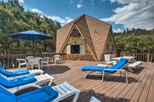 una terraza con sillas y sombrillas y una cabina en Scenic Cabin Pine Mountain Club Community!, en Frazier Park