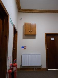 um quarto com um armário e um radiador na parede em Douglas Hotel em Glasgow