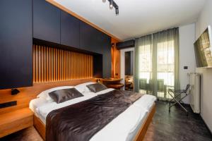 a bedroom with a large bed with a black wall at Jazine lux apartment E&T in Zadar