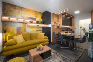 een woonkamer met een gele bank en een tafel bij Jazine lux apartment E&T in Zadar