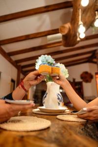 two people holding up a vase of flowers on a table at Abuela Casa Hostal in Apía