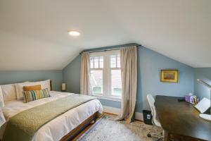 a bedroom with a bed and a desk and a window at Charming Tacoma Vacation Home with Fenced Yard in Tacoma