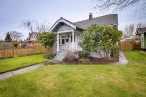a white house with a fence and a yard at Charming Tacoma Vacation Home with Fenced Yard in Tacoma