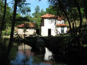 un edificio vicino a un fiume alberato di Moinho da Cruz a Ponte de Lima