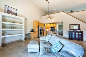 a living room with a blue couch and a kitchen at Pet-Friendly Glendale Home with Pool and Putting Green in Phoenix