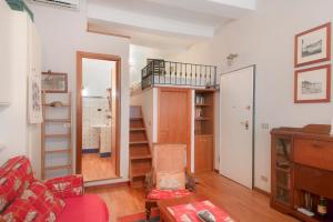 a living room with a red couch and a staircase at Monolocale Daneri 72 in Bonassola