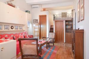 Una sala de estar con un sofá rojo y una mesa. en Monolocale Daneri 72, en Bonassola
