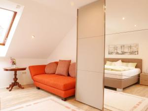 ein Schlafzimmer mit einem Bett und einem orangenen Stuhl in der Unterkunft Ferienwohnung Am Eiberg in Bad Wildbad