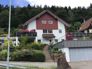 ein weißes Haus mit rotem Dach in der Unterkunft Ferienwohnung Am Eiberg in Bad Wildbad