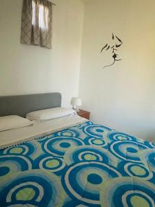 1 dormitorio con 1 cama con un patrón en la pared en B&B Antica Forneria en Capaccio-Paestum