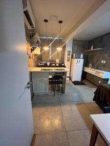 a kitchen with a table and chairs and a refrigerator at STUDIO 304 | WIFI 600MB | RESIDENCIAL JC, um lugar para ficar. in Belém