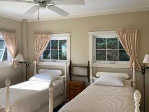 2 camas en un dormitorio con 2 ventanas en The Barn at Spry Point, en Little Pond