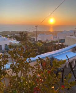 a view of a sunset over a town with a pool at Stella Nomikou Apartments in Firostefani