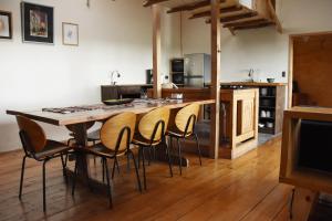 eine Küche mit einem großen Holztisch und Stühlen in der Unterkunft Casa Puente de Chiloé in Castro