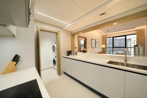 a kitchen with a sink and a washing machine at Cheval Maison - The Palm in Dubai +61 photos