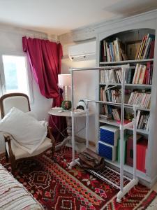 um quarto com uma cama e uma estante de livros com livros em Les Magnolias em Montbrun-les-Bains