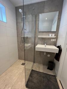 een badkamer met een douche en een wastafel bij Appartement 5 in Katwijk aan Zee