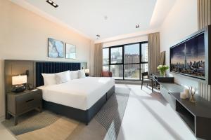 a hotel room with a bed and a tv at Cheval Maison - The Palm in Dubai