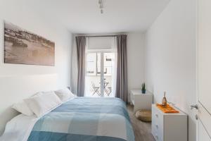 a white bedroom with a bed and a window at Le Marine Apartments in Bisceglie