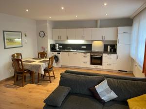 ein Wohnzimmer mit einem Sofa und einem Tisch sowie eine Küche in der Unterkunft Ferienhof Große Drieling in Greven