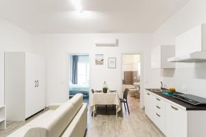 uma cozinha branca com uma mesa e uma sala de jantar em Le Marine Apartments em Bisceglie
