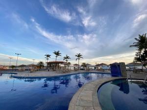 una gran piscina con mesas y sombrillas en Belíssimo Flat no Lake Side - Beira Lago en Brasilia