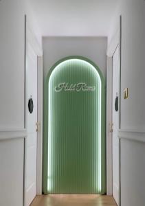 a hallway with a green door with a sign on it at Hold Rome - Luxury Suites in Rome