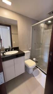 a bathroom with a toilet and a sink and a shower at Aconchegante apartamento no lago in Brasilia