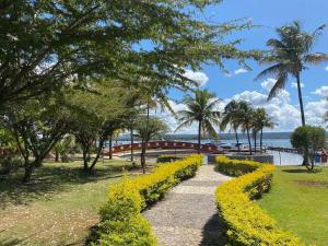 a park with a pathway and flowers and palm trees at Aconchegante apartamento no lago in Brasilia