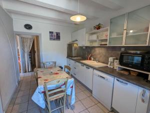 a small kitchen with a table and a microwave at Gîte Olivier in Vals-les-Bains