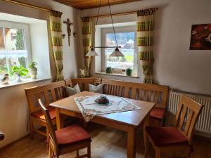 Un comedor con mesa y sillas y dos ventanas. en Ferienhaus am Bach, en Riedenburg