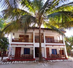 un bâtiment avec un palmier en face dans l'établissement Santa Maria Coral Park, à Pongwe