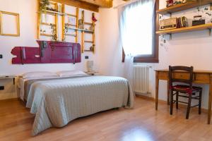 a bedroom with a bed and a desk and a table at Venice's neighbour Home in Mirano