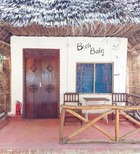Un bâtiment avec un banc et un panneau qui lit juste le bébé dans l'établissement Santa Maria Coral Park, à Pongwe