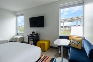 a bedroom with a bed and a couch and a tv at Aloft Austin South in Austin