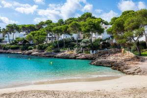 a view of a beach with houses in the background at White suites in Cala d´Or