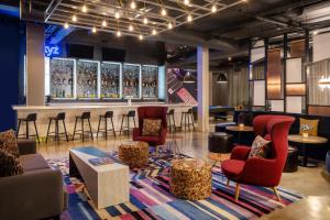 a lobby with a bar with chairs and tables at Aloft Austin South in Austin