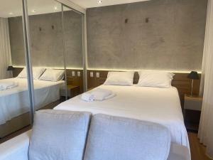 1 dormitorio con 2 camas con espejos y 2 sillas en Luxuoso Flat Lake Side com vista para o lago, en Brasilia