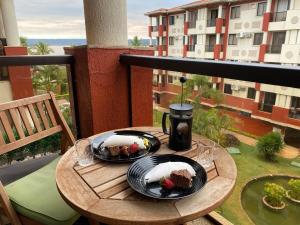 una mesa con 2 platos de comida en el balcón en Luxuoso Flat Lake Side com vista para o lago, en Brasilia