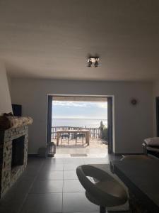 a living room with a fireplace and a view of the ocean at ALICIA in Zonza